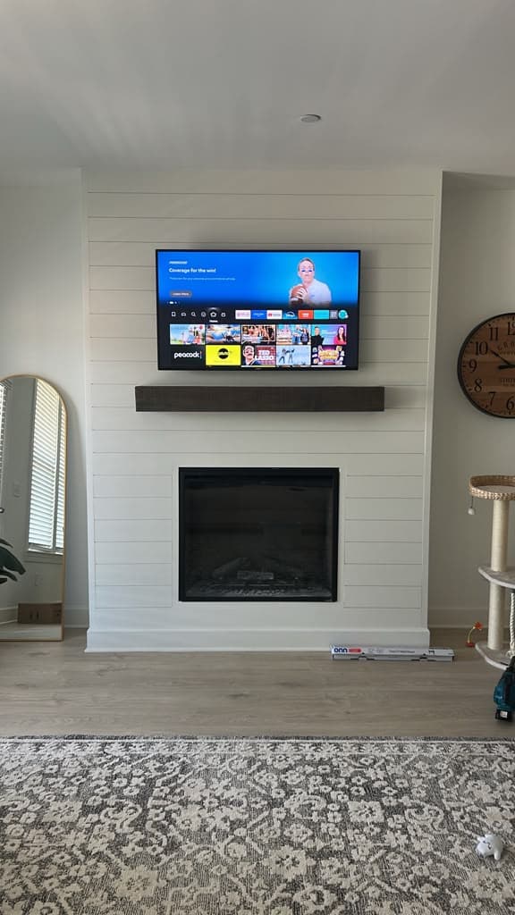 TV mounted above a white shiplap fireplace with a dark floating mantel and concealed cables, Nashville TN